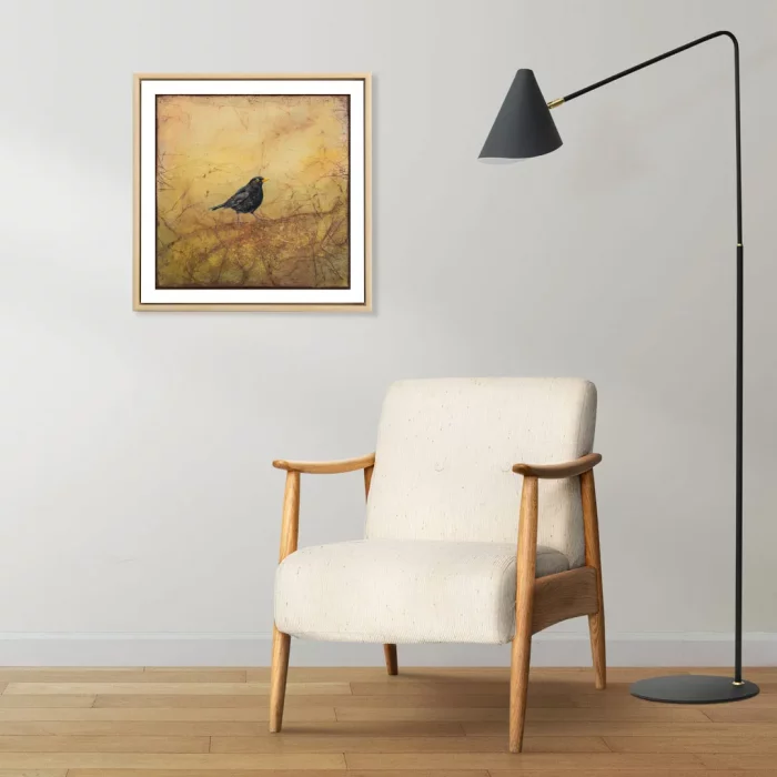Vizualizace obrázku ptáčka v dřevěném rámečku na šedé stěně.